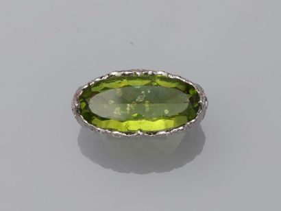 null 18k white gold ring presenting a peridot of about 10cts in the center of a fine...