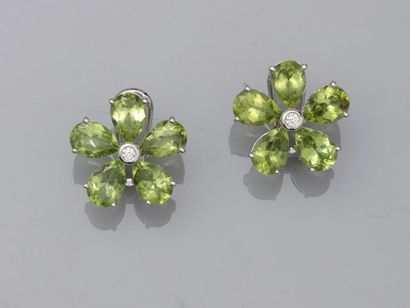 null Pair of 18k white gold flower ear clips with peridots for about 8cts in total...