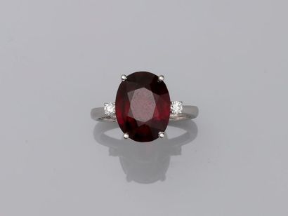 null Bague en or blanc 18k présentant un important grenat rhodolite ovale de 7cts...