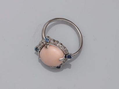 null 18k white gold ring surmounted by an angel skin coral cabochon encircled by...