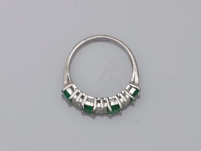 null 18k white gold line ring surmounted by four oval emeralds alternating with three...