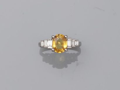 null 18k white gold ring surmounted by a yellow sapphire of about 1.50cts with baguette-cut...