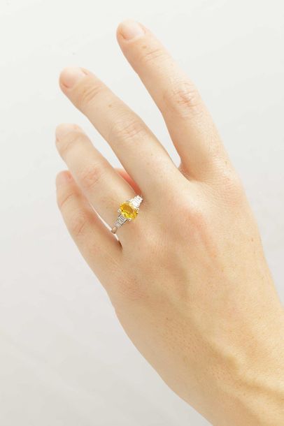 null 18k white gold ring surmounted by a yellow sapphire of about 1.50cts with baguette-cut...