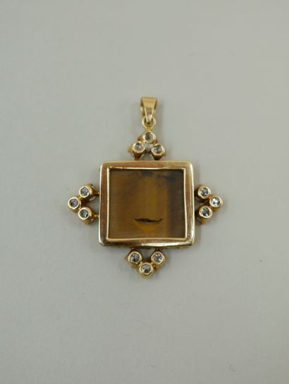 null An 18k yellow gold square pendant set with a rectangular tiger eye quartz intaglio...