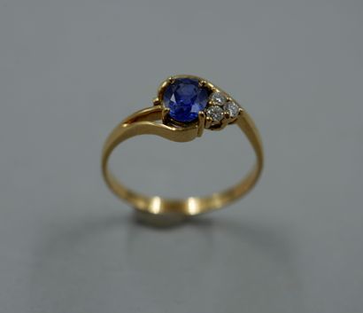 null 18k yellow gold ring with openwork scrolls topped by a 1ct sapphire and three...