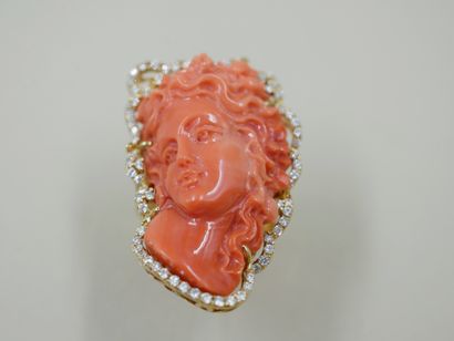 null 18k yellow gold ring surmounted by a woman's face with wavy coral hair surrounded...