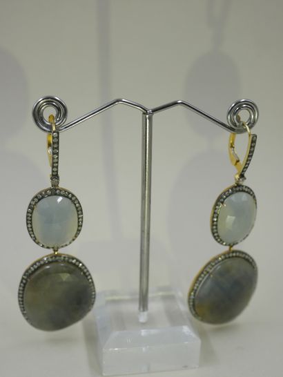 null A pair of silver and 18k yellow gold earrings holding two faceted sapphires...