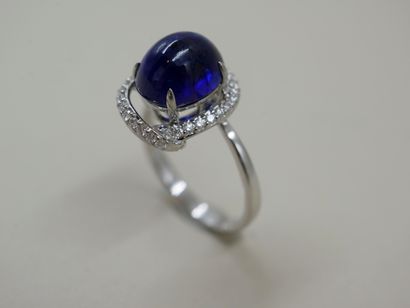 null 18k white gold ring set with a 4cts cabochon sapphire surrounded by a sinuous...