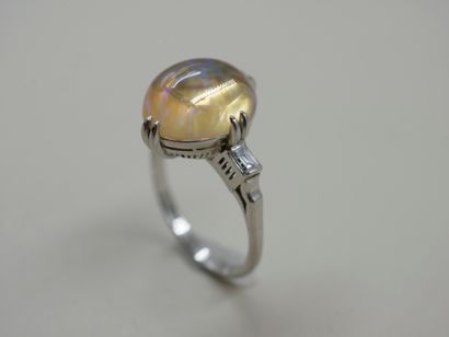 null NON VENU - Bague en or blanc 18k griffée d'une opale en cabochon épaulée de...