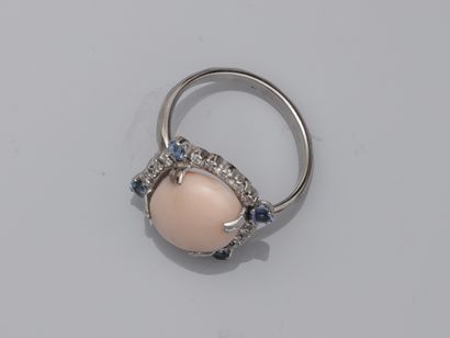 null Ring in 18k white gold surmounted by an angel skin coral cabochon encircled...