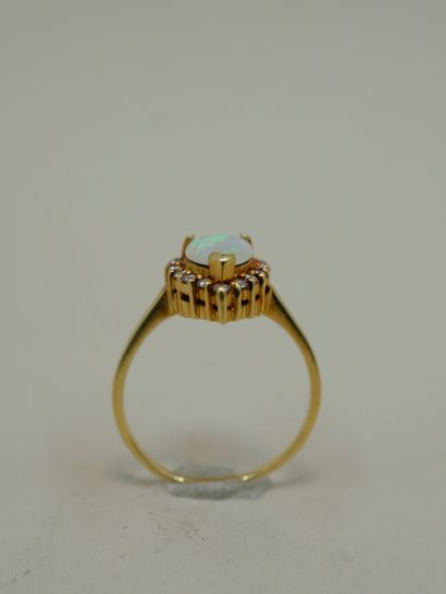 null 18k yellow gold ring surmounted by a pear-cut opal encircled by a line of diamonds...