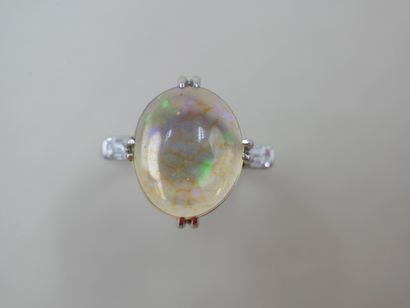 null NON VENU - Bague en or blanc 18k griffée d'une opale en cabochon épaulée de...