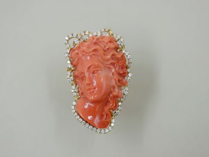 null 18k yellow gold ring surmounted by a woman's face with wavy coral hair surrounded...