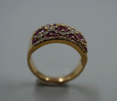 null Band ring in 18k yellow gold set with oval rubies in a diamond-paved lattice...