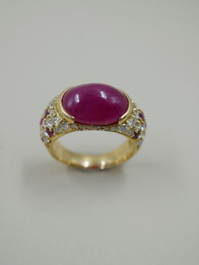 null 18k yellow gold band ring set with a cabochon ruby in a closed setting and paved...