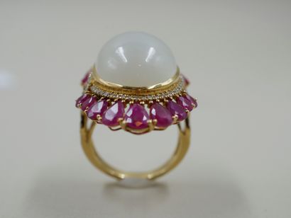 null 18k yellow gold ring set with a large cabochon moonstone surrounded by falling...