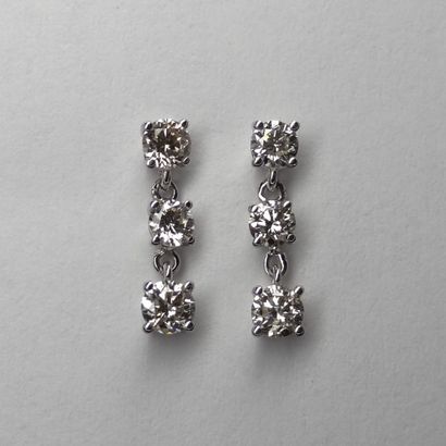 null Pair of 18k white gold earrings set with a line of three diamonds in pendants...
