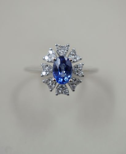 null 18k white gold flower ring set with an oval sapphire weighing approximately...