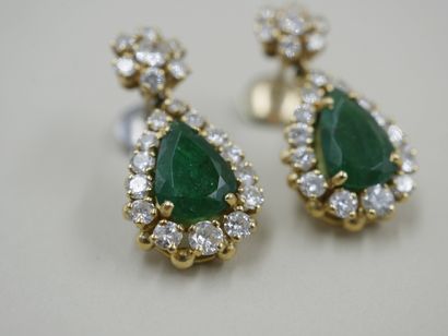 null A pair of 18k yellow gold earrings set with pear-cut emeralds in a diamond setting...