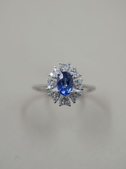 null 18k white gold flower ring set with an oval sapphire weighing approximately...