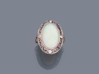 null 18k white gold ring surmounted by an oval opal in an openwork setting set with...