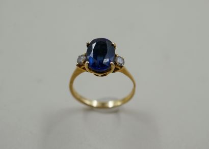 null 18k yellow gold ring set with an oval sapphire and synthetic sapphire doublet...