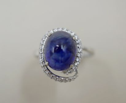 null 18k white gold ring set with a 4cts cabochon sapphire surrounded by a sinuous...