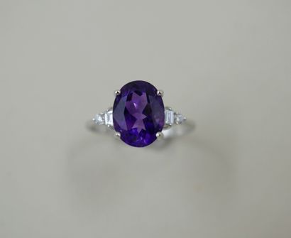 null Ring in 18k white gold set with an oval amethyst, with two baguette diamonds...