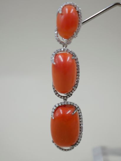 null Pair of 18k white gold earrings holding three oval coral cabochons by diamond...
