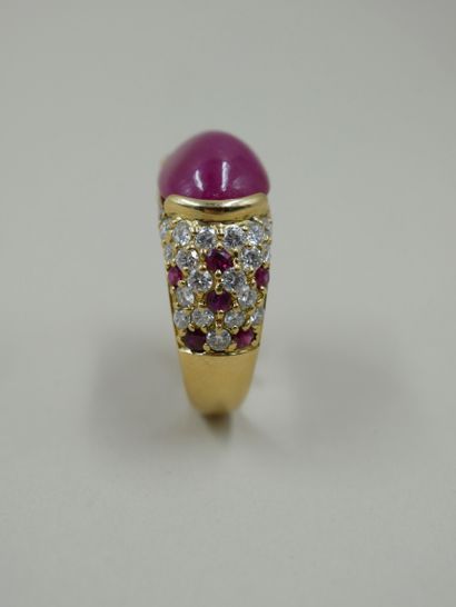 null 18k yellow gold band ring set with a cabochon ruby in a closed setting and paved...