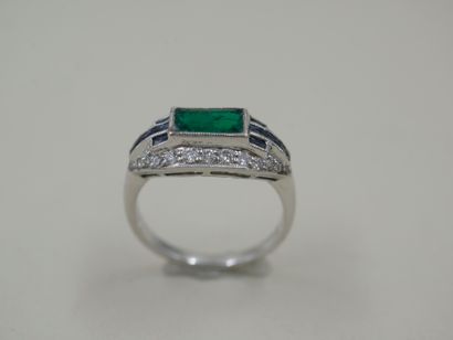 null Platinum ring surmounted by a rectangular emerald surrounded by lines of calibrated...