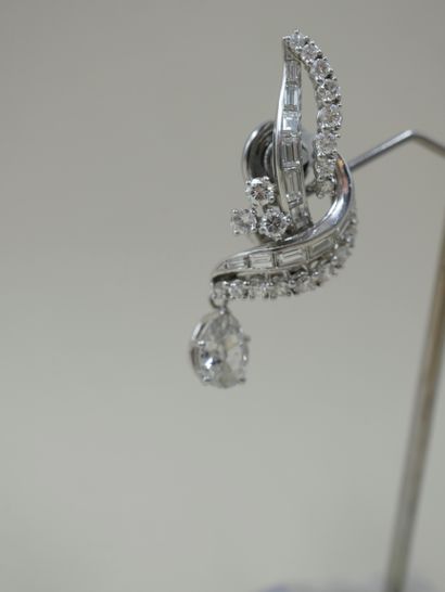 null A pair of 18k white gold and platinum ear clips, each set with baguette diamonds...