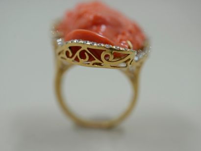 null 18k yellow gold ring surmounted by a woman's face with wavy coral hair surrounded...