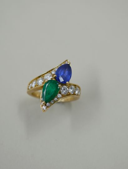 null An 18k yellow gold "You and I" ring set with a sapphire and an emerald each...
