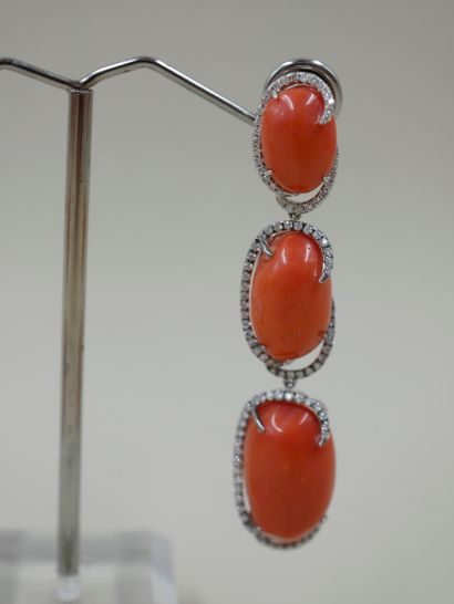 null Pair of 18k white gold earrings holding three oval coral cabochons by diamond...