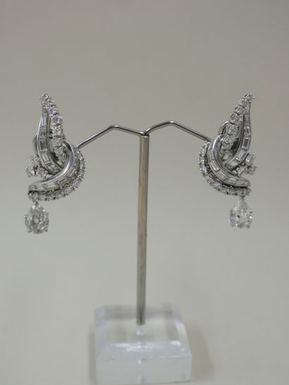 null A pair of 18k white gold and platinum ear clips, each set with baguette diamonds...