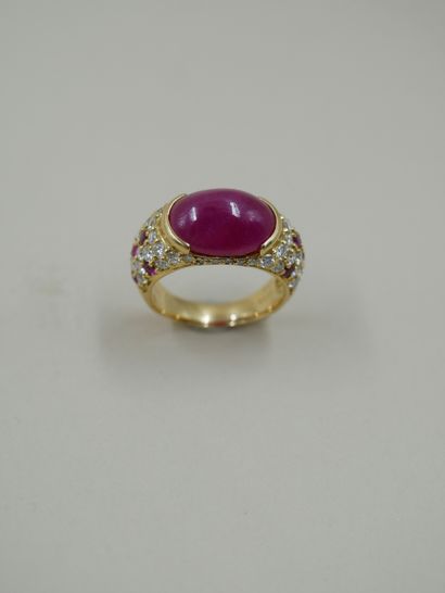 null 18k yellow gold band ring set with a cabochon ruby in a closed setting and paved...