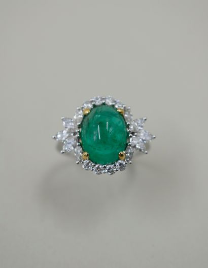 null 18k white gold ring set with an oval cabochon emerald surrounded by brilliant-cut...