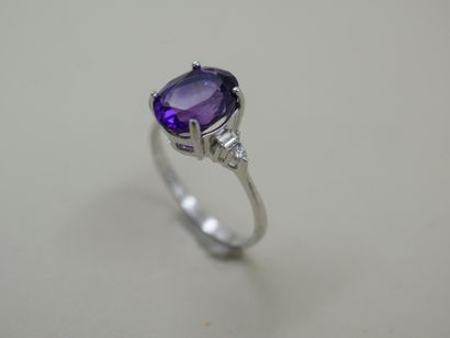 null Ring in 18k white gold set with an oval amethyst, with two baguette diamonds...