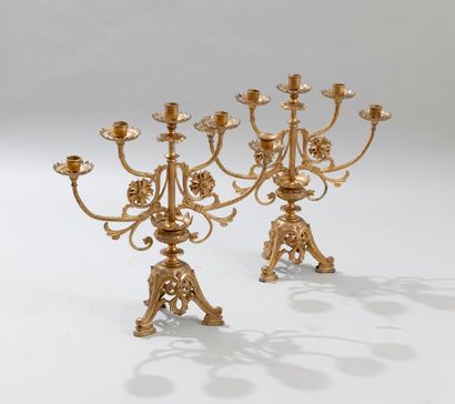null A pair of gilt bronze candlesticks resting on a tripod base with leafy consoles....