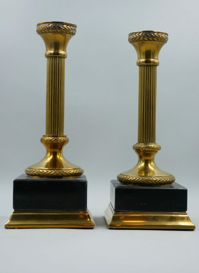  Pair of brass candlesticks, fluted shaft. Quadrangular base in resin. Height 27...