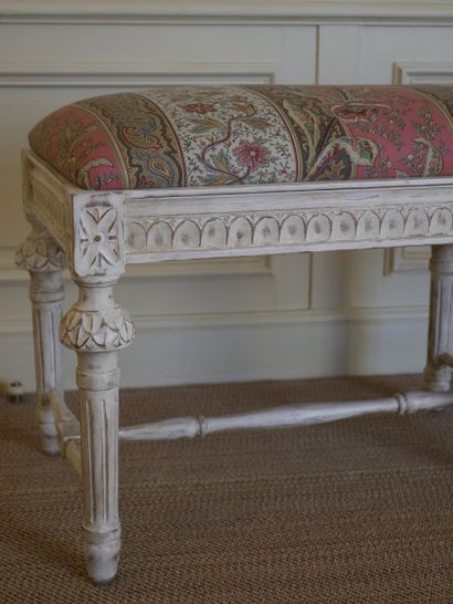 null Bench in carved wood lacquered cream, standing on six tapered fluted legs joined...