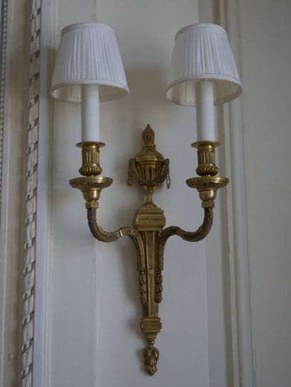 null A pair of Louis XVI style ormolu sconces with two arms of light, the shaft topped...