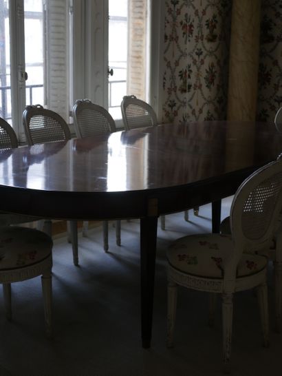 null A large mahogany and mahogany veneer dining room table with fluted legs and...