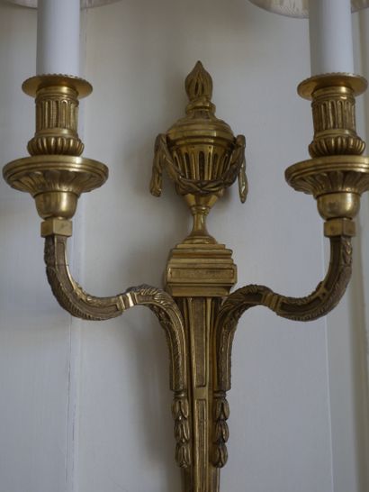 null A pair of Louis XVI style ormolu sconces with two arms of light, the shaft topped...