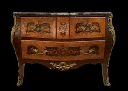 null A curved chest of drawers made of inlaid wood with floral scrolls, opening with...