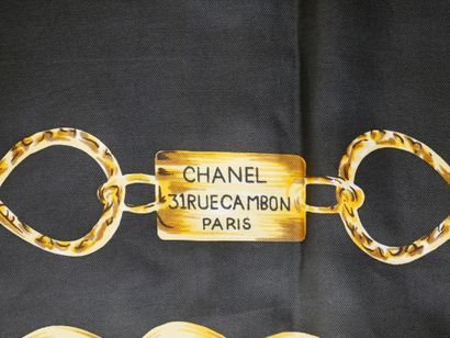 null CHANEL. Foulard en soie à motif de chaînes dorées et logo sur fond noir mentionnant...