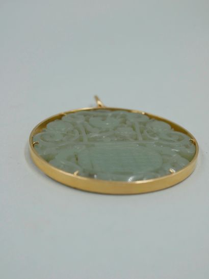 null Pendentif circulaire en or jaune 18K serti d'une plaque de jade sculpté et ciselé...