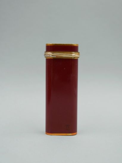 null CARTIER. Briquet en laque rouge et plaqué or. Dans sa boite, complète de ses...