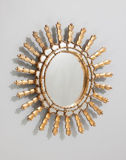 null Oval mirror with moulded and gilded wood glazing with a radiant motif, in the...